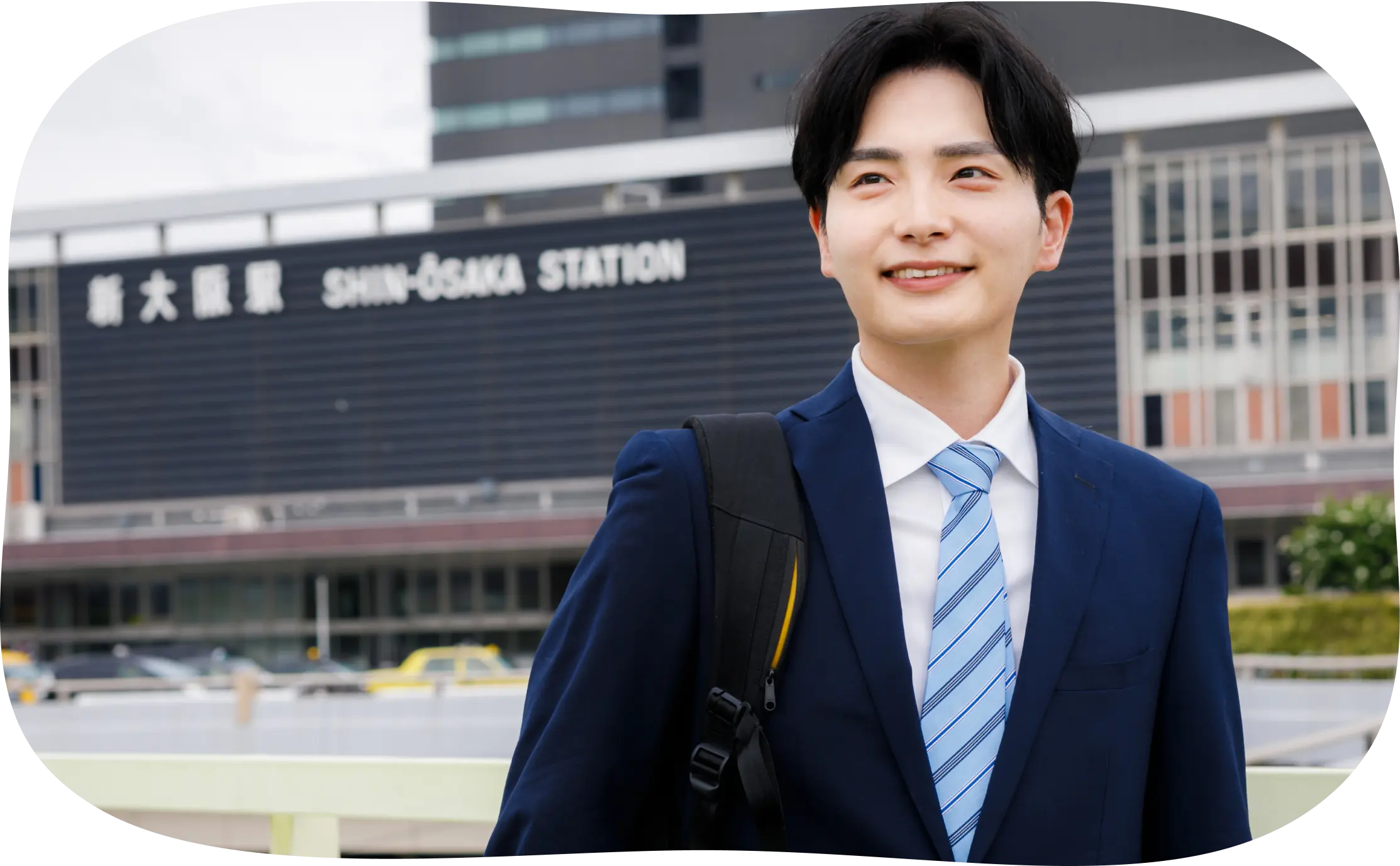 新大阪駅前に立っている男性の写真